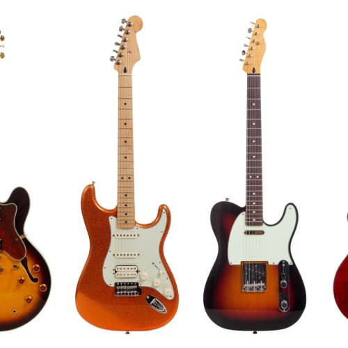 A group of six assorted guitars on a white background