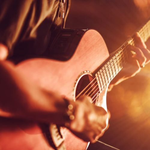 Acoustic Guitar Playing. Men Playing Acoustic Guitar Closeup Photography.