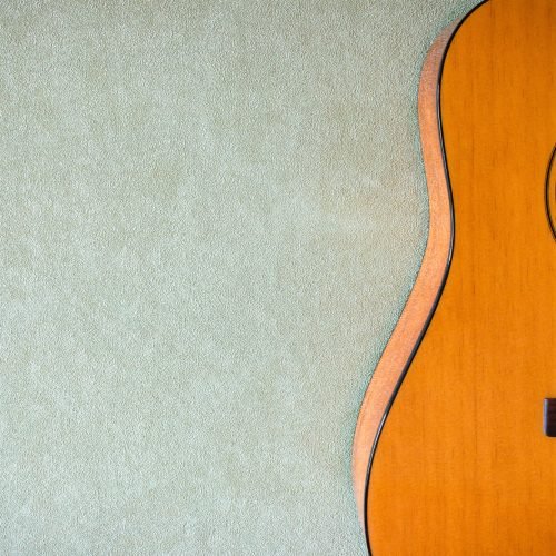 half of an acoustic guitar on a blank background