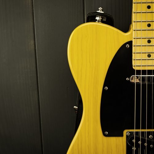 Details of a classic electric guitar in yellow and black, with its frets, strings, neck and microphone