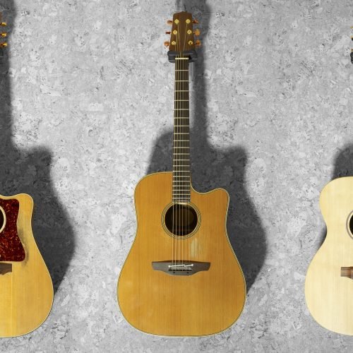 3 classic guitars hanging on a wooden wall